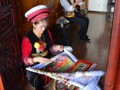 A woman creating an embroidered picture.