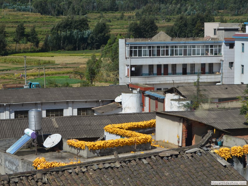 Ears of corn drying on roof's along the way.