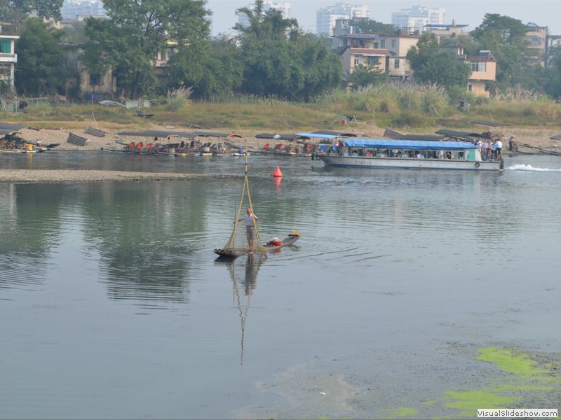 A fisherman using an unusal net in the river.