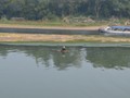 Another fisherman in the river on his bamboo boat