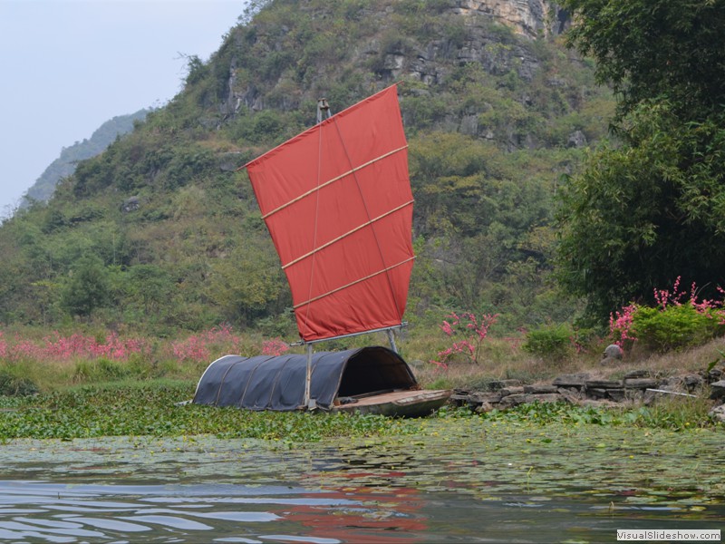 A sail boat that was docked along the river.