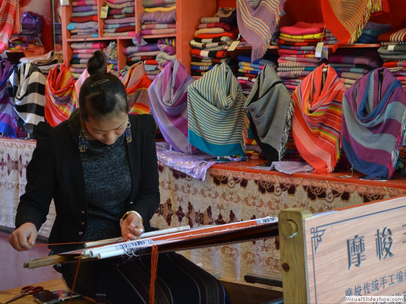 A weaver making colorful shawls.