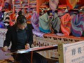 A weaver making colorful shawls.