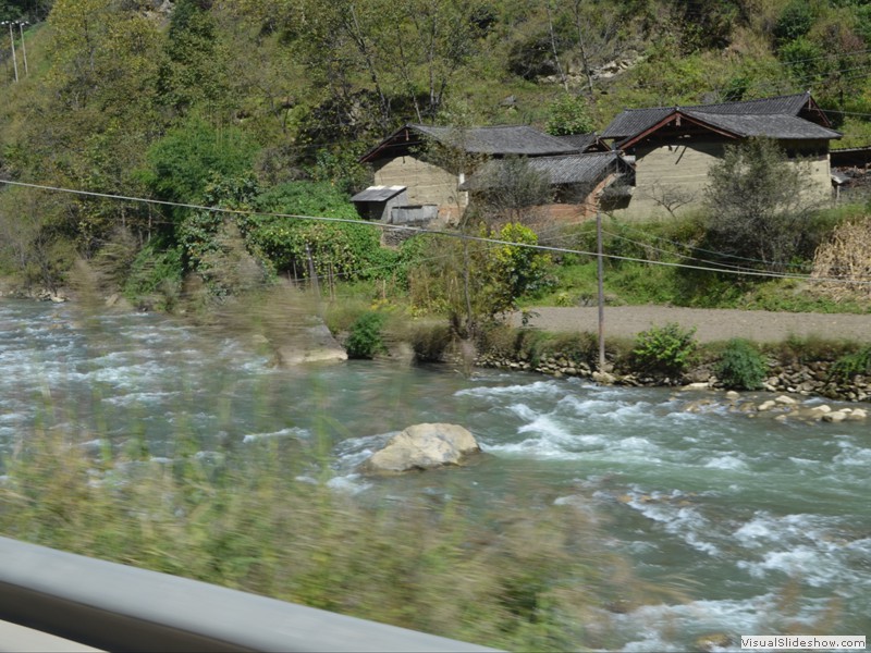 A mountain stream flows beside the road.