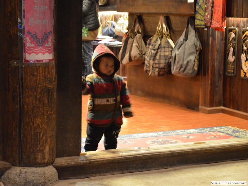 A small child watching the people passing by.
