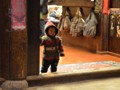 A small child watching the people passing by.
